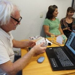 Ein Mann sitzt mit einem Laptop an einem Tisch