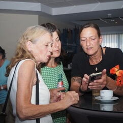 Drei Frauen schauen auf ein Handy