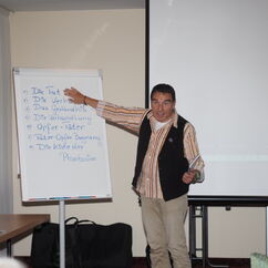 Ein Mann zeigt auf ein Flipchart und erklärt etwas