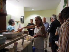 Eine Frau schaut in die Kamera und nimmt sich etwas zu Essen von einem Buffet