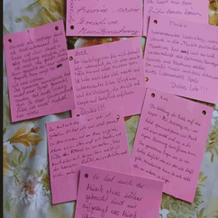 Beschriftete rote Zettel liegen auf einem Tisch.